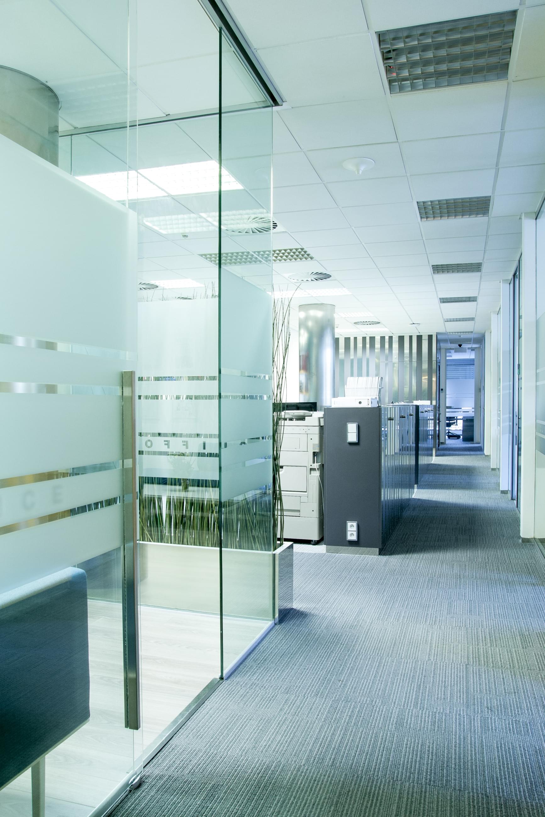 View of the open space part of the offices, which are separated by glass partitions in combination of clear glass and milk glass.