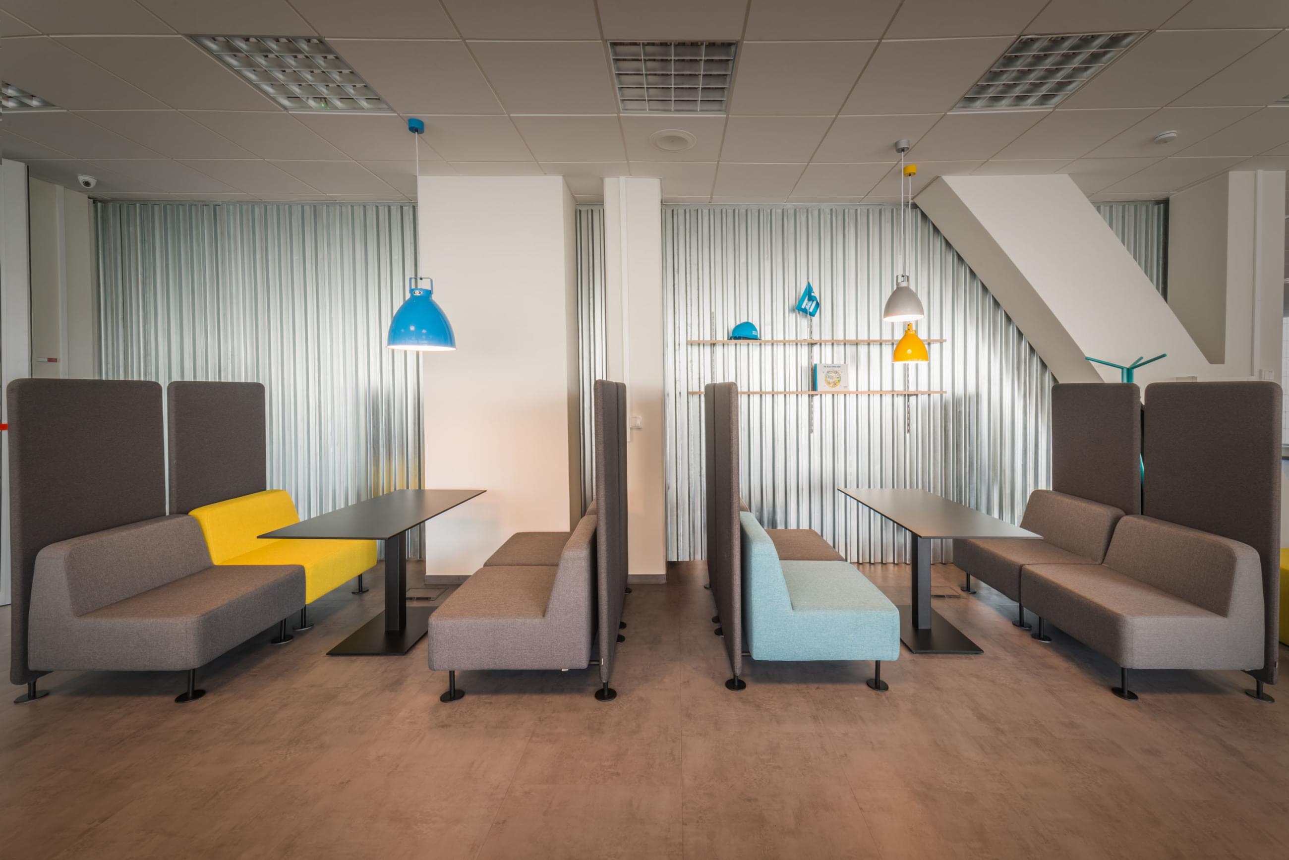 Seating in the lobby is enhanced by accessories with distinctive colors like blue and yellow chandeliers and a blue helmet.