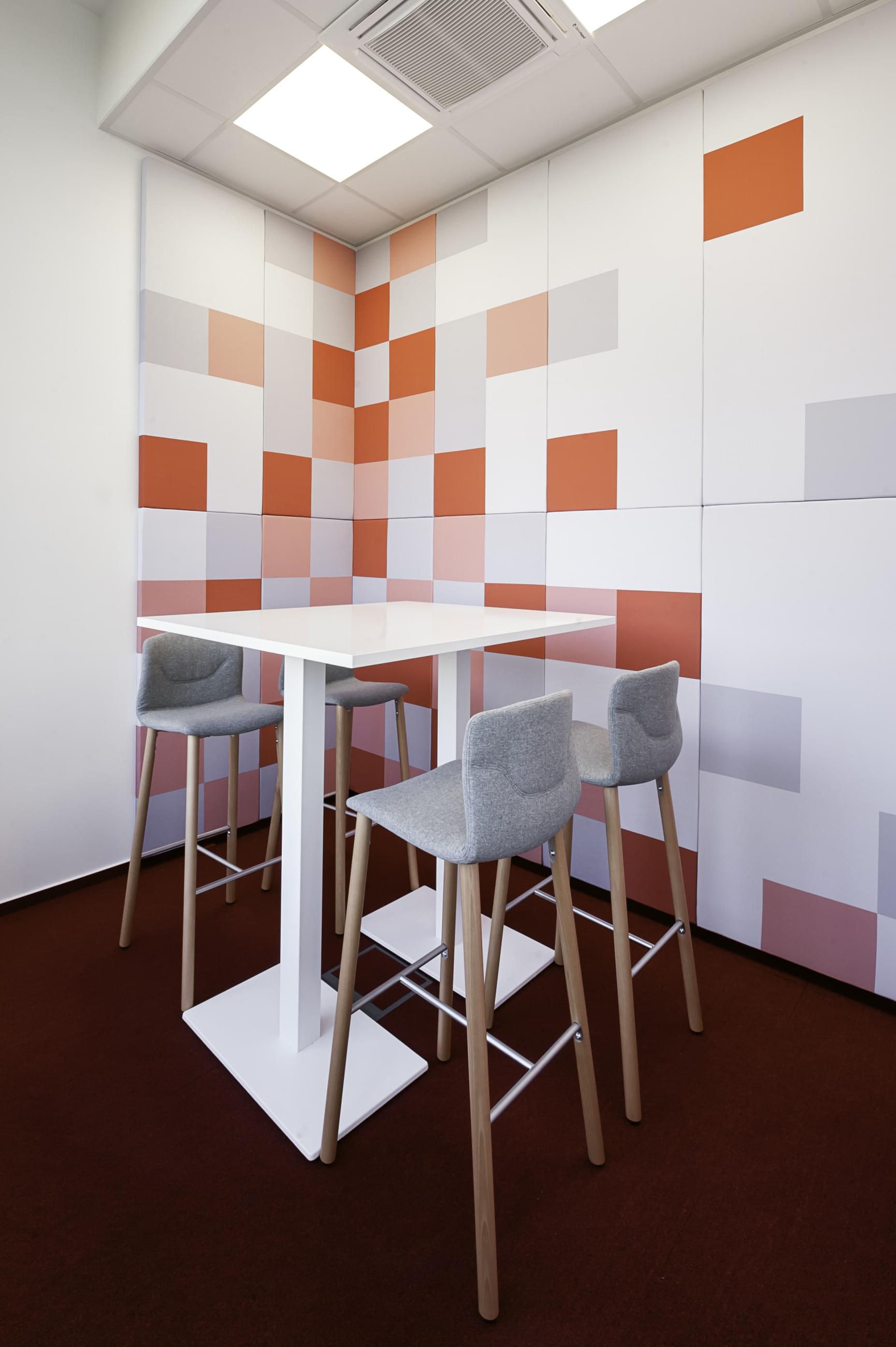 Moderní odpočinková místnost s veselým designem oživuje kreativní tapeta se čtvercovými vzory. Tapeta zpříjemňuje atmosféru místnosti.