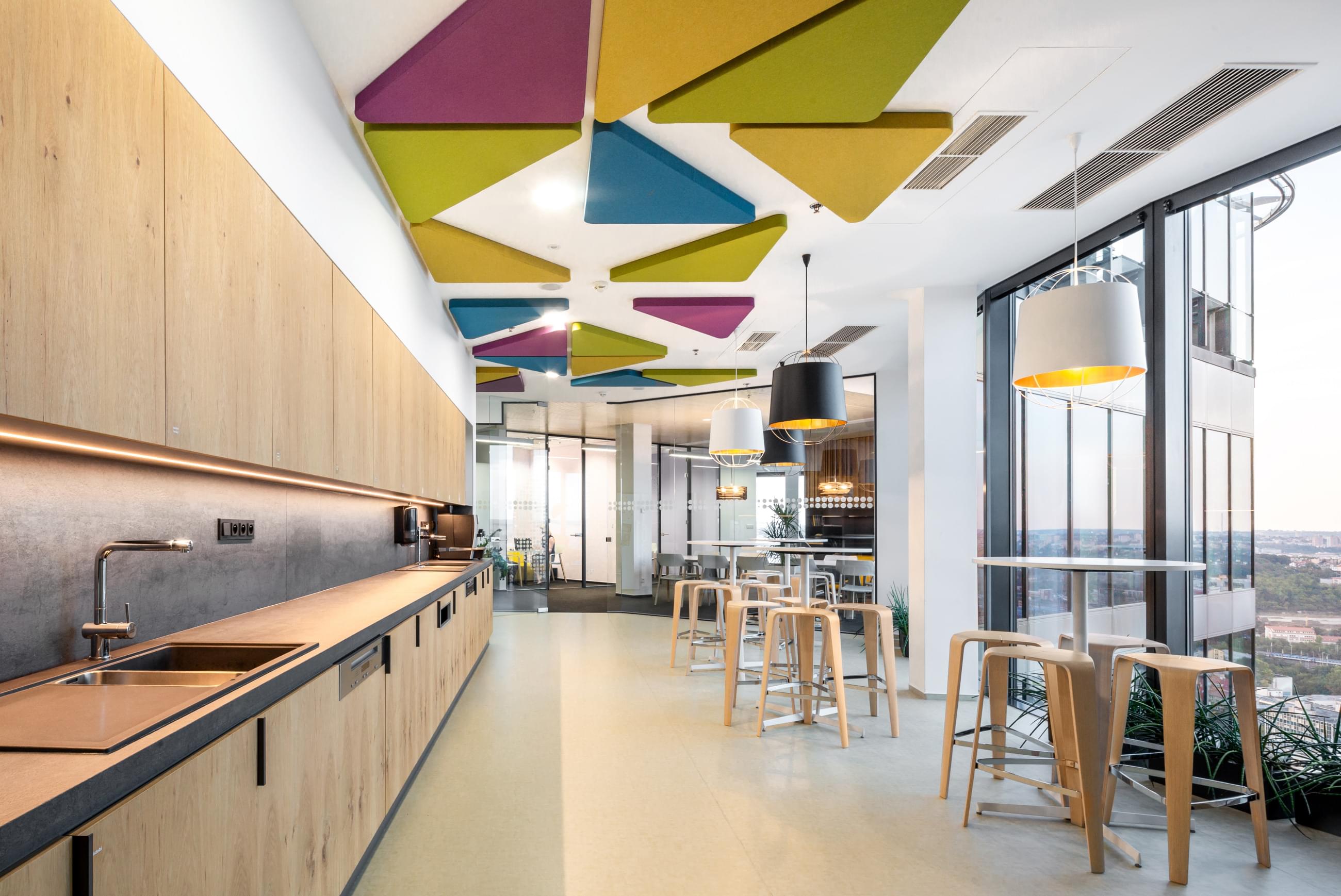 Kuchyňka pro zaměstnance s moderním interiérem a akustickými panely ve firmě Passerinvest. 