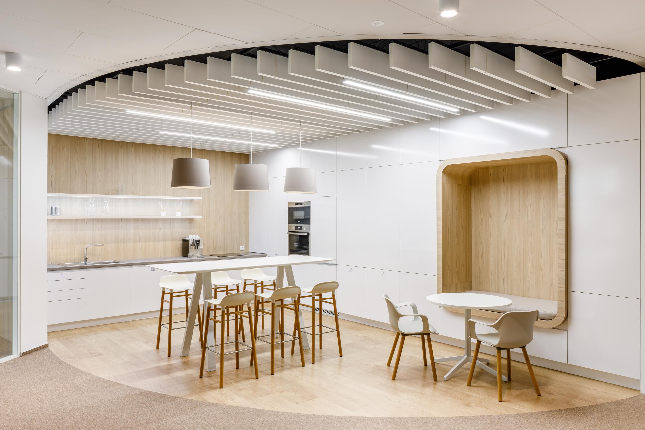 Pracovní kuchyňka ve světlých barvách vhodně doplněna o pohodlnou pohovku pro zaměstnance firmy ČAP