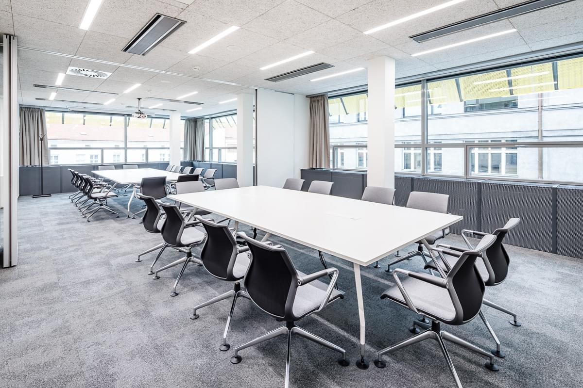 Zasedací místnost v bílých barvách s moderním interiérem ve společnosti Sev.en Energy. 