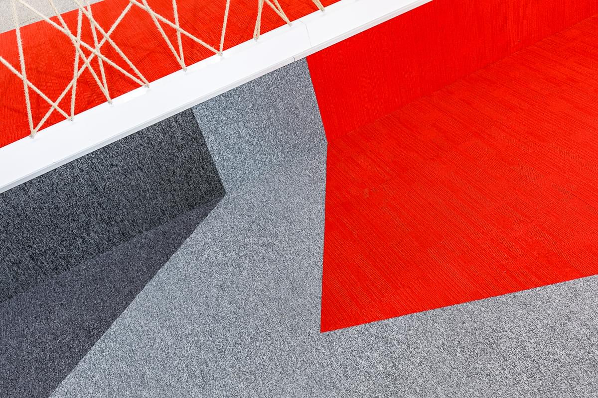 Detail na koberec ve firemních barvách doplněný dekoračním lanem ve firmě Seznam