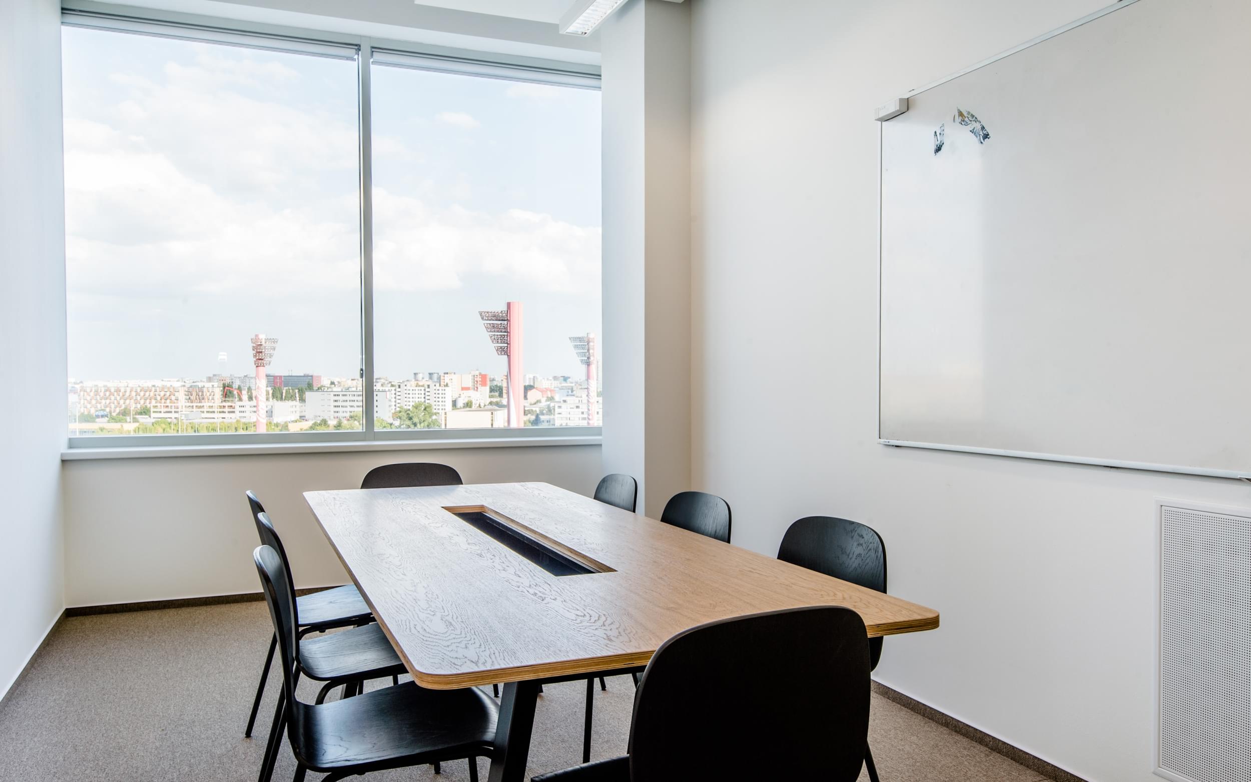 Zasedací místnost s velkým okem a výhledem na město.