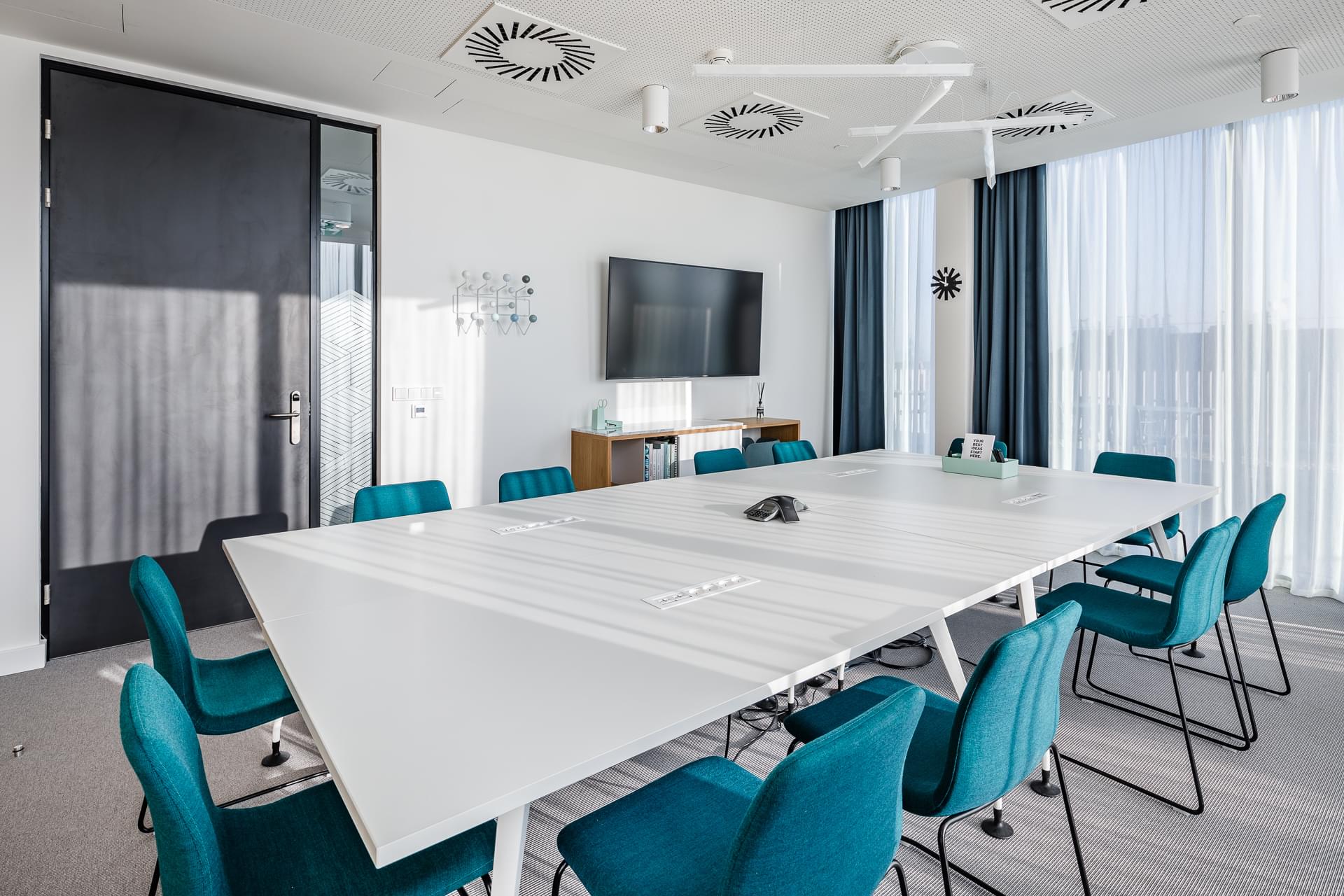 Airy meeting room with table, in which are built-in electrical sockets, skylight, glass partition
