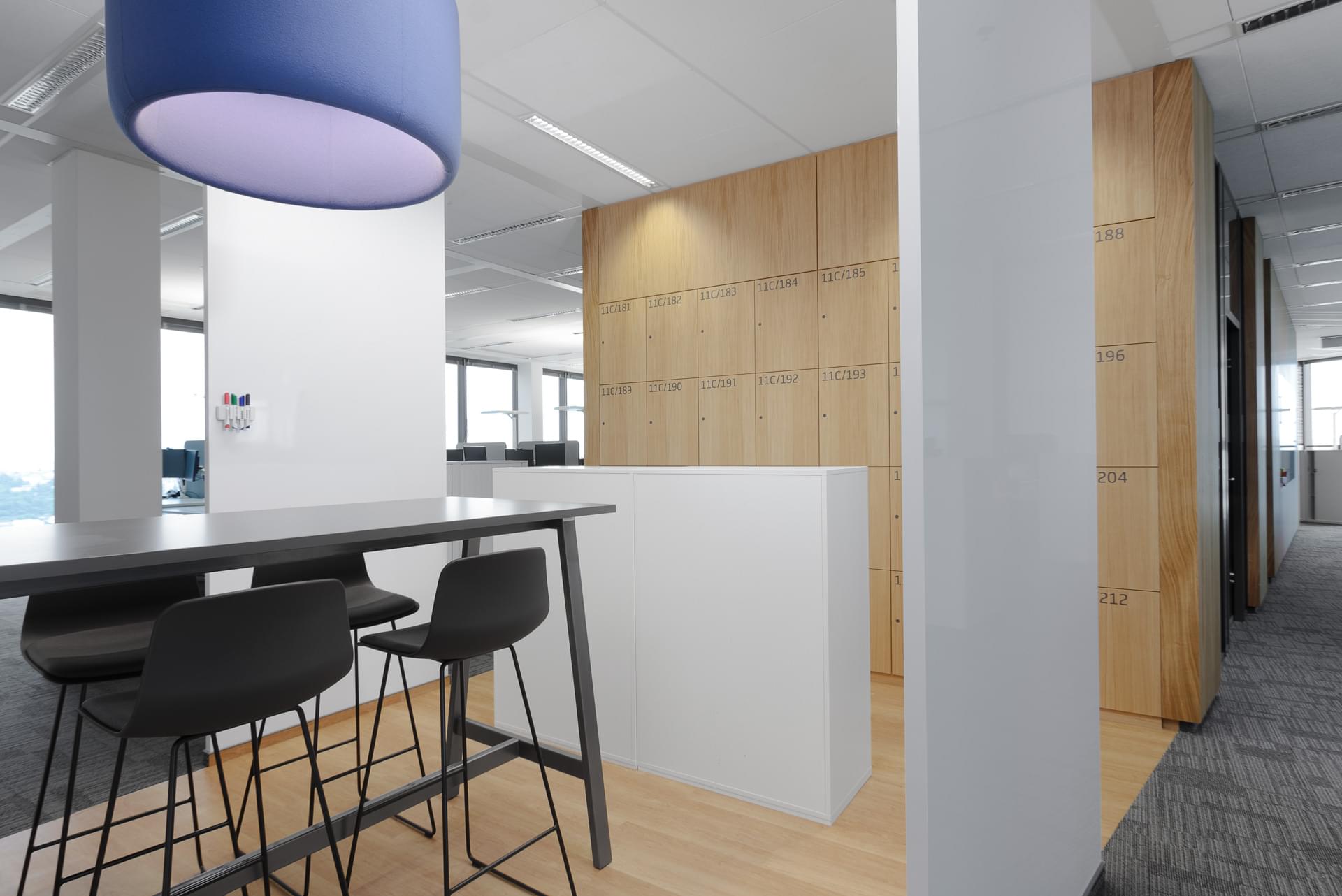 Lockable lockers in wooden design next to the bar table in the company UniCredit Bank