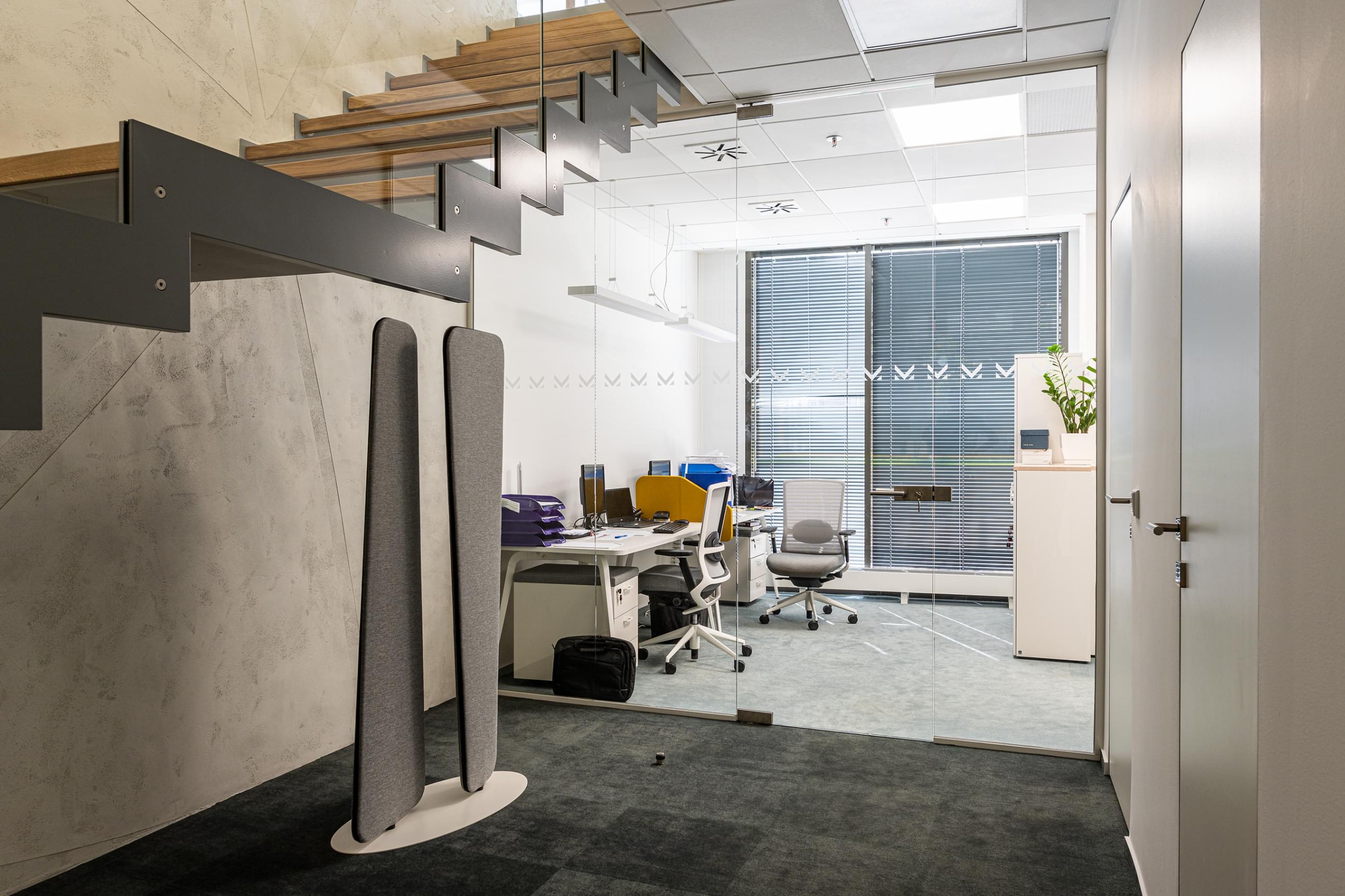 Ocelová boční schodnice a subtilní skleněné zábradlí vytváří jedinečný vzhled ve firmě MS Invest