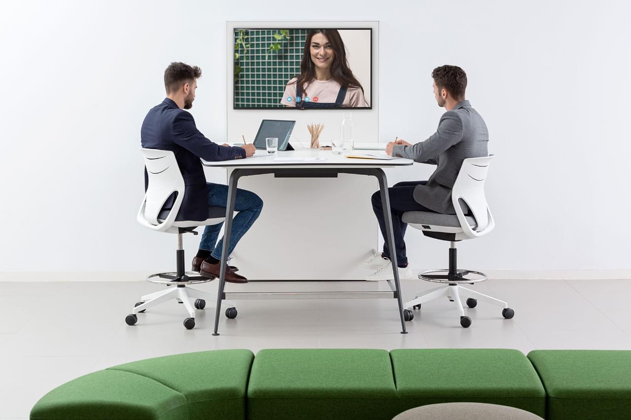 Dva muži při videohovoru v kanceláři. 