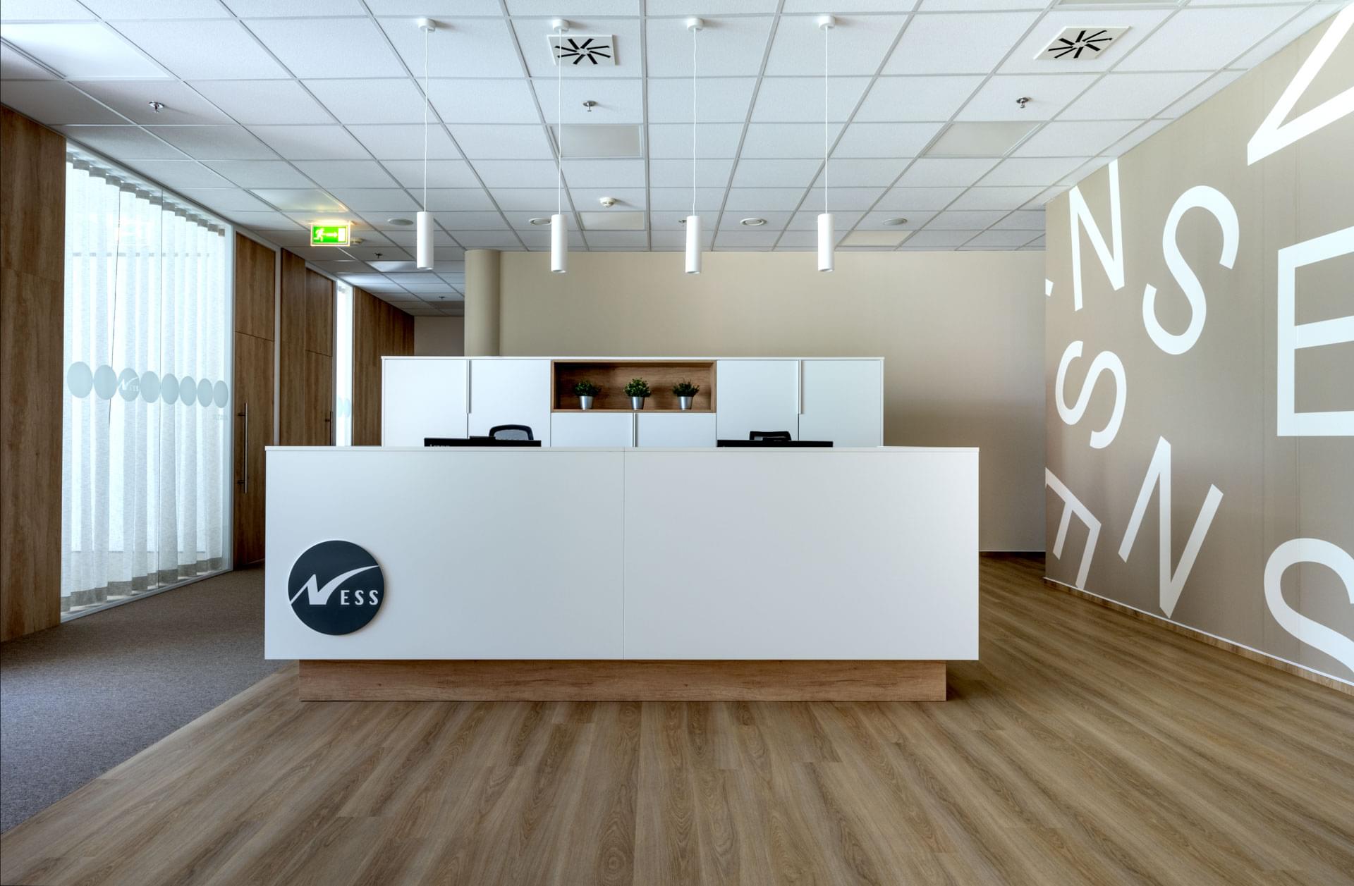 Podsvícená recepce v bílém provedení s tapetovou stěnou 