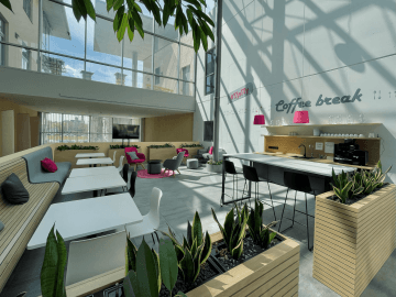 Atypical seating in the form of wooden benches with decorative elements in company colours