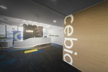 Pohled na recepci kanceláří Cebia. Je tvořena podsvíceným pultem a systémem úložných prostor.