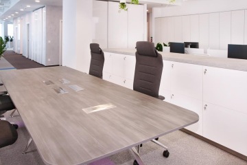 Offices are equipped with gray-tone furniture and concrete-like surfaces.