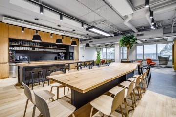 Minimalist corporate kitchen with large bar table and kitchen island