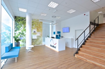 The ResMed's in-house reception, consisting of a reception desk with a company logo and a blue armchair for visits diversified with natural motif wallpaper.