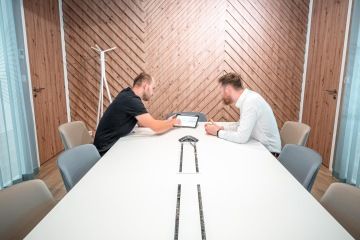 Jídelní místnost s protáhlým stolem a lavicí na sezení v kancelářích Samsung