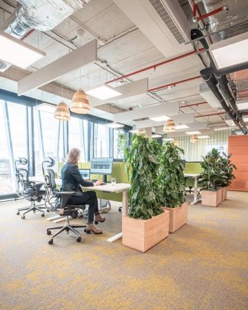 Jídelní místnost s protáhlým stolem a lavicí na sezení v kancelářích Samsung