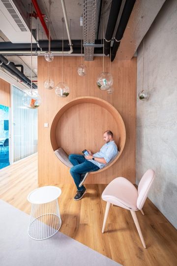 Jídelní místnost s protáhlým stolem a lavicí na sezení v kancelářích Samsung