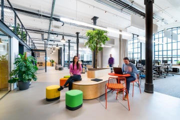 Jídelní místnost s protáhlým stolem a lavicí na sezení v kancelářích Samsung