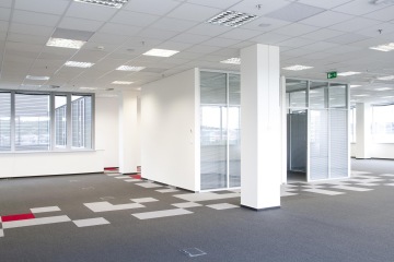 A look at the internal unobstructed areas where the office openspace is located, on the right is a glass meeting room and carpet tiles are laid across the area.