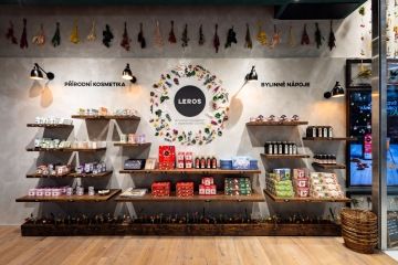 Stěna se zavěšenou květinovou výzdobou a dřevěnými policemi