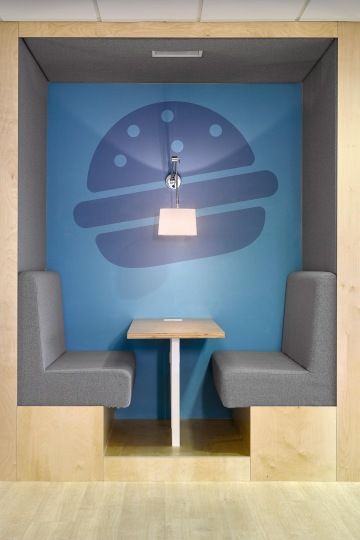 Místo k práci i odpočinku s čalouněnou lavicí a tapetou s piktogramem.