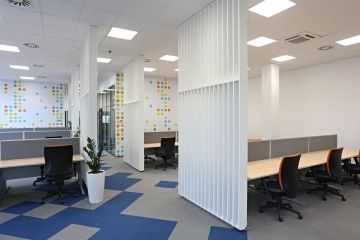 Pracovní pozice jsou od sebe odděleny paravány, na tapetách se opakuje motiv v okrové barvě.