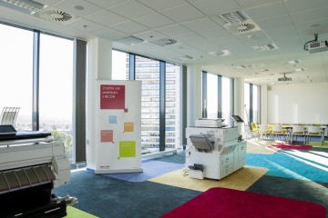 Veselý design kancelářské místnosti skvěle doplňuje barevný koberec se čtvercovými motivy.