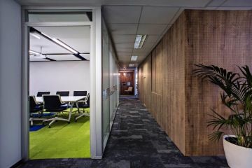 The view of the corridor, where the meeting rooms are separated by glass partitions, at the same time, the rooms are separated by different types of carpet squares, here are the hues for the corridor and the green-violet for the meeting room.