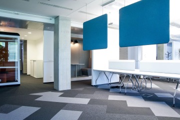 Prostorný relaxační koutek laděný do chladných barev je vhodně doplněn bílým interiérem. Interiér zpestří i koberec s motivem opakujících se šipek.