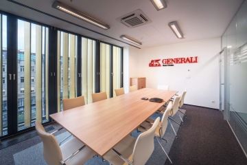 Zasedací místnost je vybavena židlemi Actiu v krémovém odstínu a je doplněna logem společnosti.