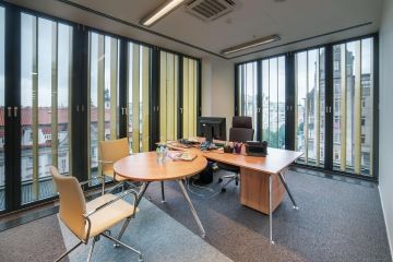 Atmosféra kanceláře laděné do zlatých tónů reaguje na světelné odlesky venkovních zlatých lamel.