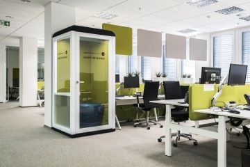 Open space kancelář s veselým designem v zelených barvách doplňují akustické závěsné panely. V kanceláři se nachází micro office při potřebě soukromí.
