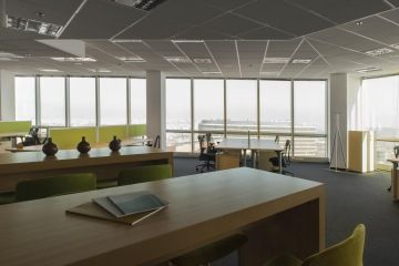 Open space office with a modern interior tuned to the natural colors. Vases on the table give the office an unusual design.