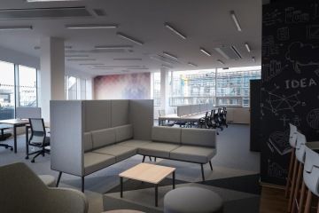 Odpočinkovou zónu odděluje akustická sedačka Longo za níž lze vidět tapetu v barevných tónech.