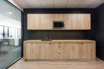 Spacious wooden kitchen with dark coloring.