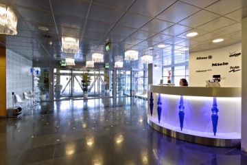 Bílá recepce Diamond Point s modrými prvky a led podsvícením v pozadí s velkým vchodem a skleněným osvětlením.