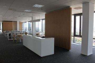 Prostor recepce v Dell showroomu je oddělen skleněnou příčkou a květinou.