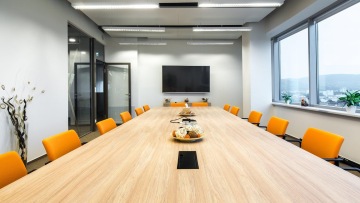 Implementation of a meeting room with wooden conference table in corporate colors of the company FINGO