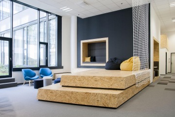 Relaxační zóna s variabilním nábytkem a dřevěným pódiem