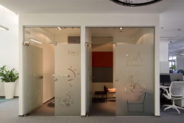 Meeting rooms with labeled glas partitions.