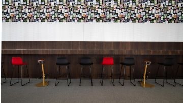 Barové stoličky ladící se šedým kobercem ve firmě IMMOFINANZ