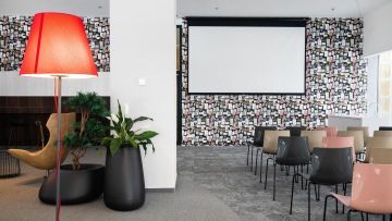 Přednášková místnost s plátnem a designovými židlemi ve společnosti IMMOFINANZ
