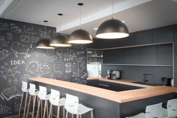 Firemní kuchyňka s ostrůvkem a barovými židlemi s popisovatelnou stěnou ve společnosti Arca Consulting