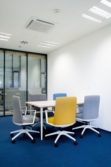 Zasedací místnost s designovým interiérem oddělená od chodby prosklenou stěnou