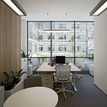 Illuminated openspace tuned into light tones with wooden elements.