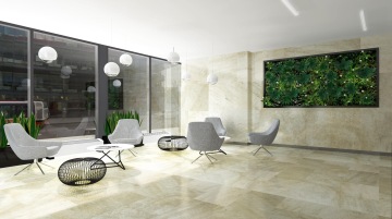 Odpočinková zóna pro zaměstnance s komfortním interiérem ve formě šedo popelavých křesel pro větší pohodlí. Moderní design místnosti skvěle doplňují lampy a květiny.