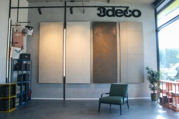 Designové koženkové křesílko v zeleném provedení v showroomu 3deco s černým logem