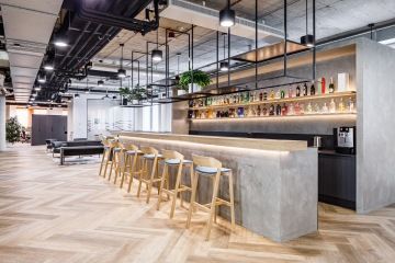 Betonový barový stůl s prvky dřeva a kovu v industriálním interiéru společnosti Becherovka