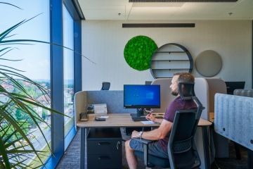 Open space office with plant elements and screens for more privacy