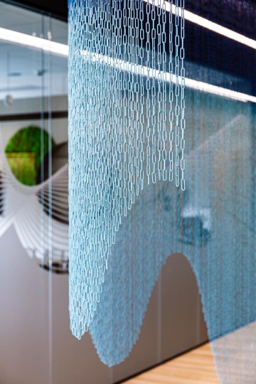 The illusion of a cramped space is created by a glass partition in the office